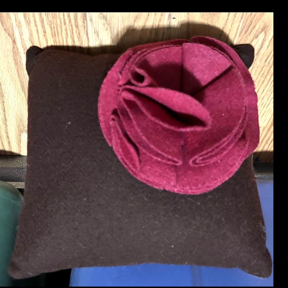 Small,dark-colored pillow with a magenta flower. World Market